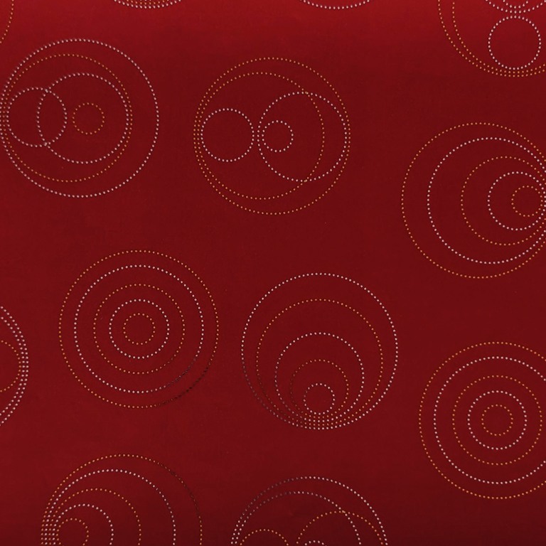 Cadeaupapier goud en zilver metallic glanzende stippen in cirkelvorm met een diep mat rode achtergrond.
 